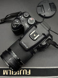 Fujifilm FinePix S200EXR compact digital camera with attached zoom lens and wrist strap