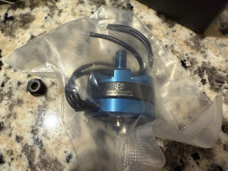 Blue RC aircraft drone motor with wired leads in clear plastic packaging