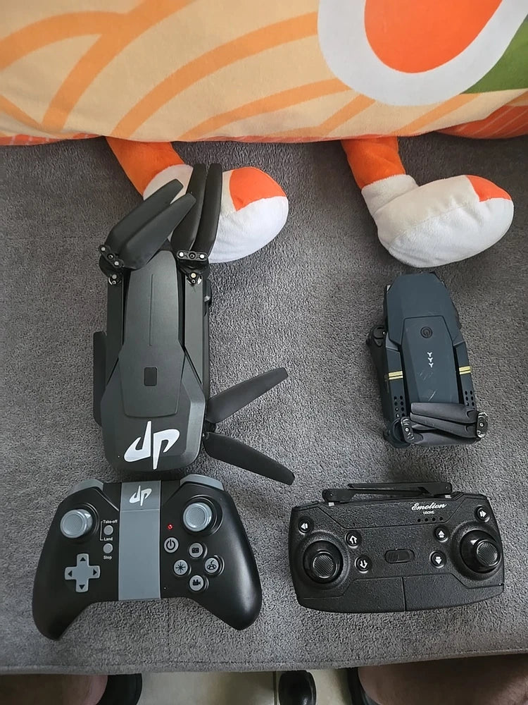 Black quadcopter drone with two game controllers on a carpeted surface