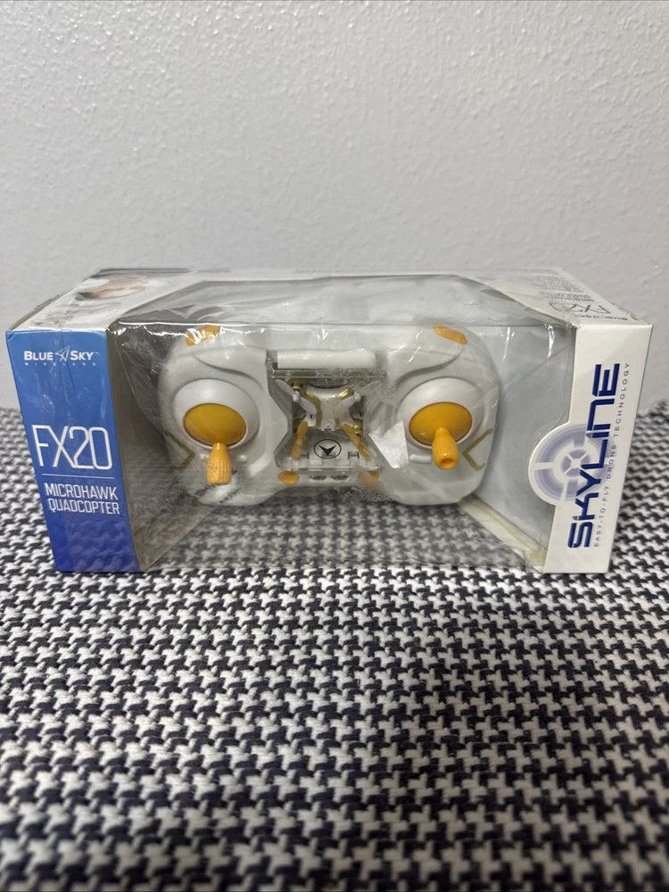 Mini quadcopter drone in clear retail box, yellow knobs and prop arms