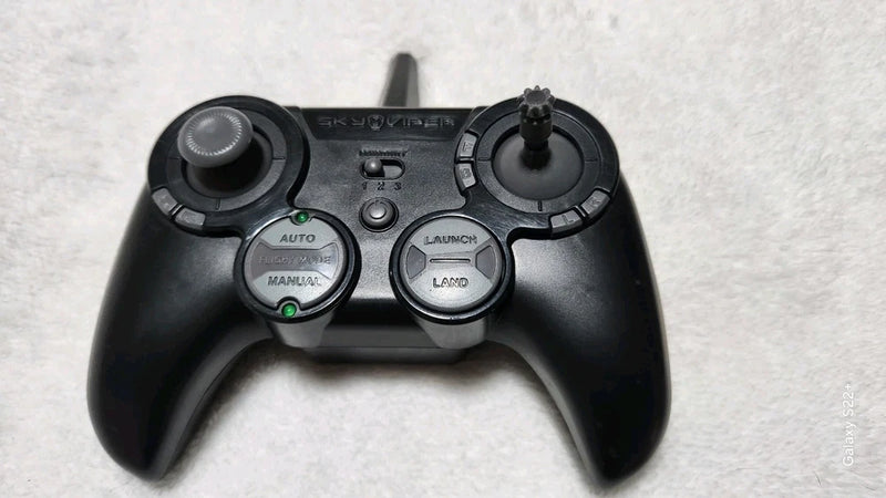 Black drone controller gamepad with two thumbsticks and central button panel