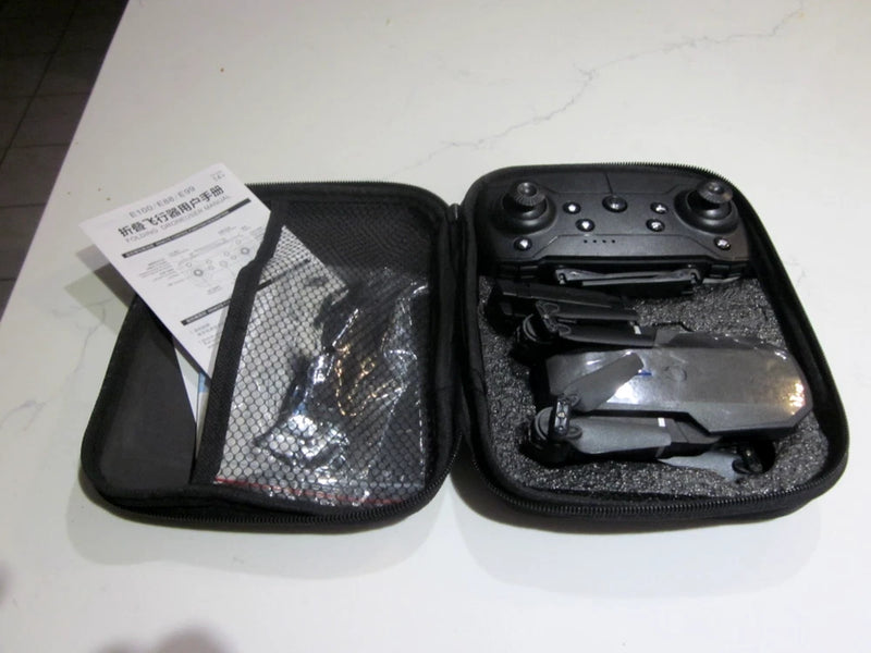 Foldable black drone in zippered carry case with controller and accessories