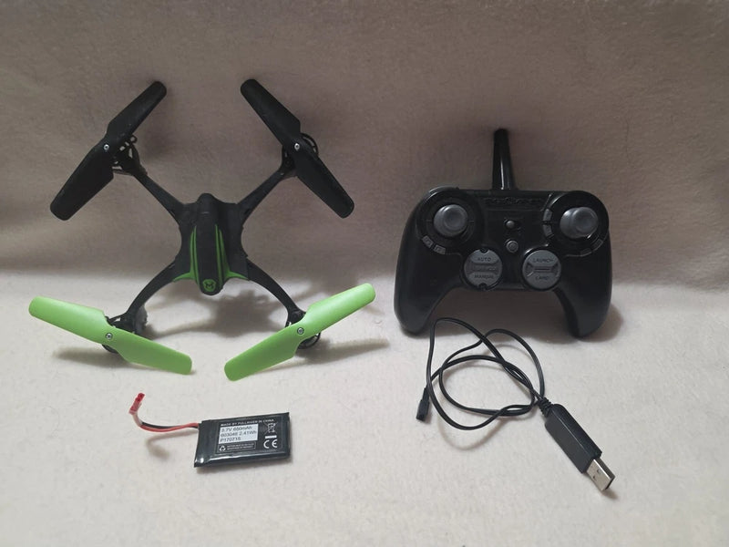 Stunt quadcopter drone with green arms, black propellers, and RC controller with cable.