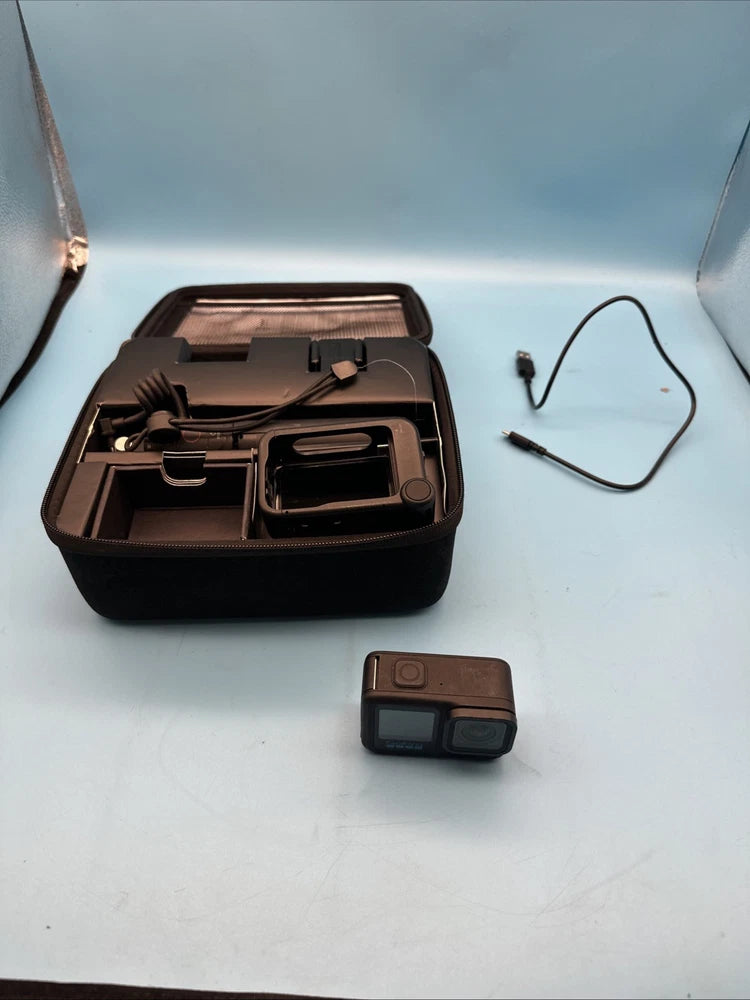 Black action camera in protective case with visible accessories and mount