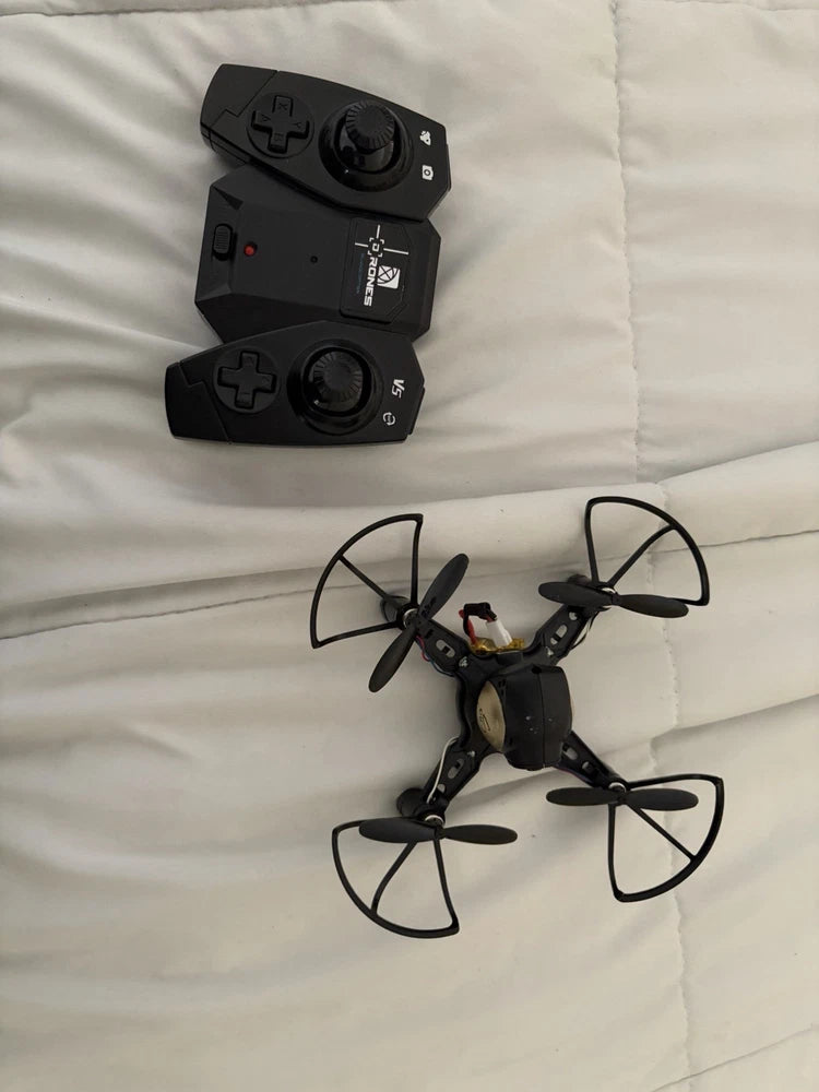 Mini quadcopter drone with four propellers and black remote controller