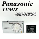 Silver compact digital camera with lens and Panasonic LUMIX battery pack