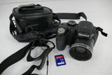 Black Fujifilm FinePix digital camera with zoom lens, hand strap, and carrying case