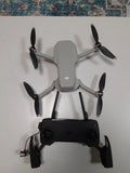 Gray quadcopter drone with four propellers and remote controller