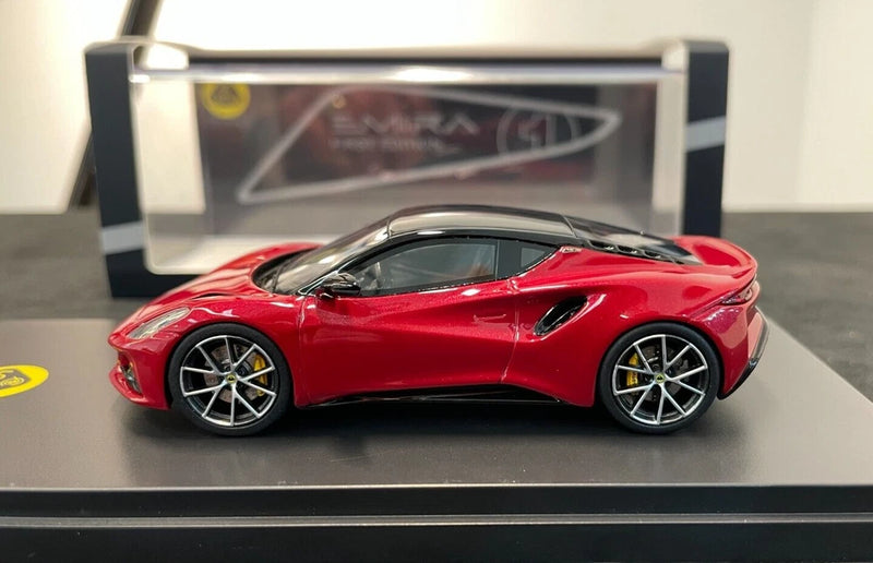 Magma red 1:43 scale Lotus Emira model car with black roof, side view, in clear display case