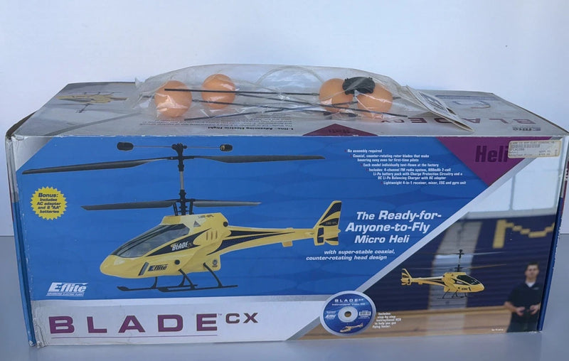 RC helicopter model in retail box with illustrated yellow helicopter and blue packaging