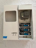 GoPro HERO+ waterproof action camera in open box with mounted housing and stickers
