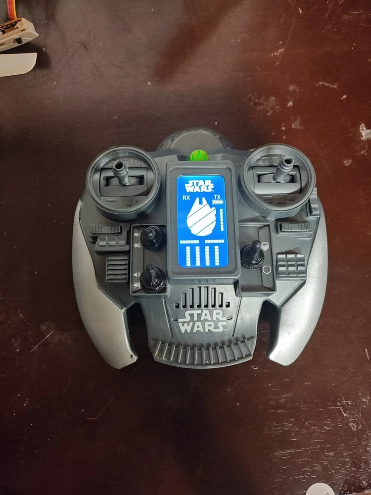 Gray handheld drone remote controller with two thumb sticks and Star Wars graphic display