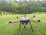X4 heavy lift drone with red arms, landing legs, and front camera gimbal