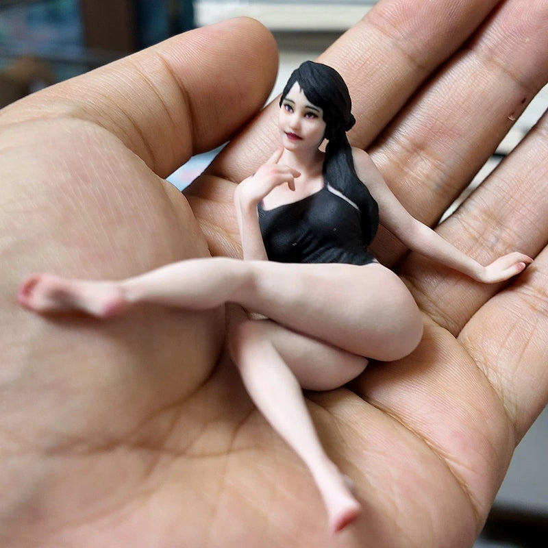 Miniature resin figurine of a reclining woman in black outfit