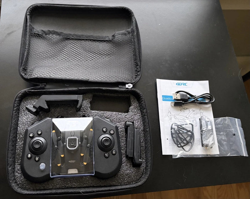 Mini drone with camera, black controller and cables in a zip storage case