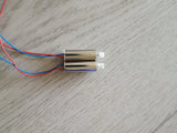 Pair of drone motors with blue and red wiring and white electrical connectors
