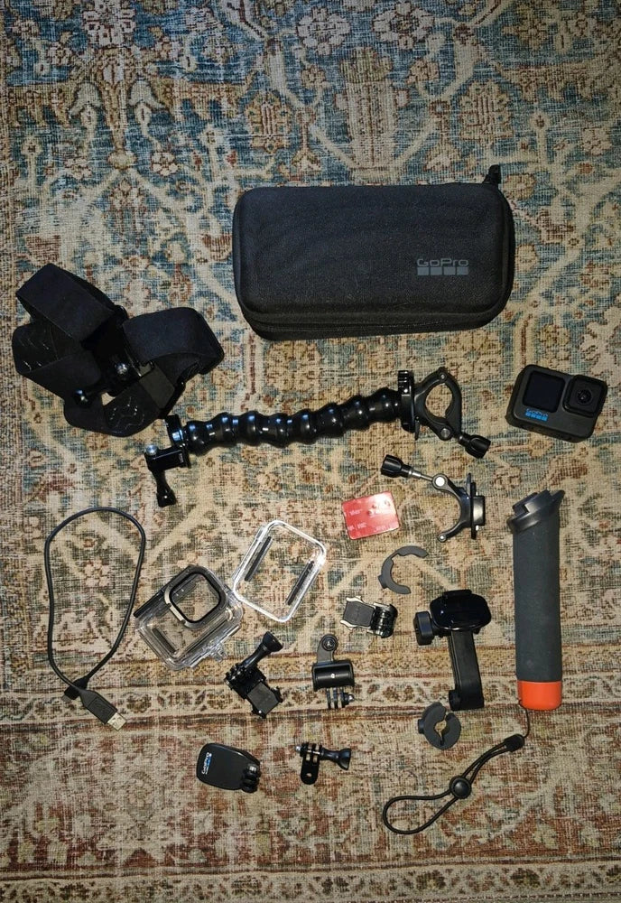 Black GoPro Hero11 action camera with carry case, mounts, selfie stick, and accessories