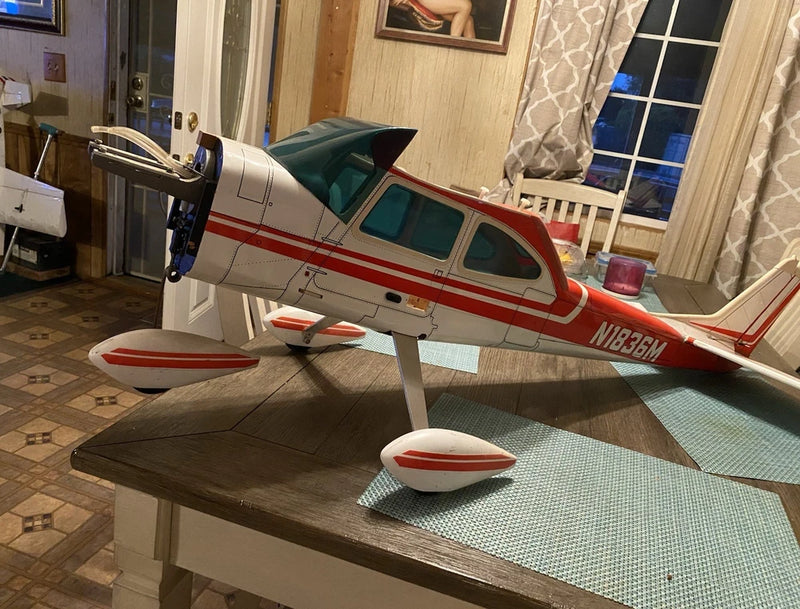 RC airplane fuselage and wing with landing gear, red-and-white model aircraft