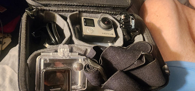 Silver action camera in hard case with waterproof housing and mounts