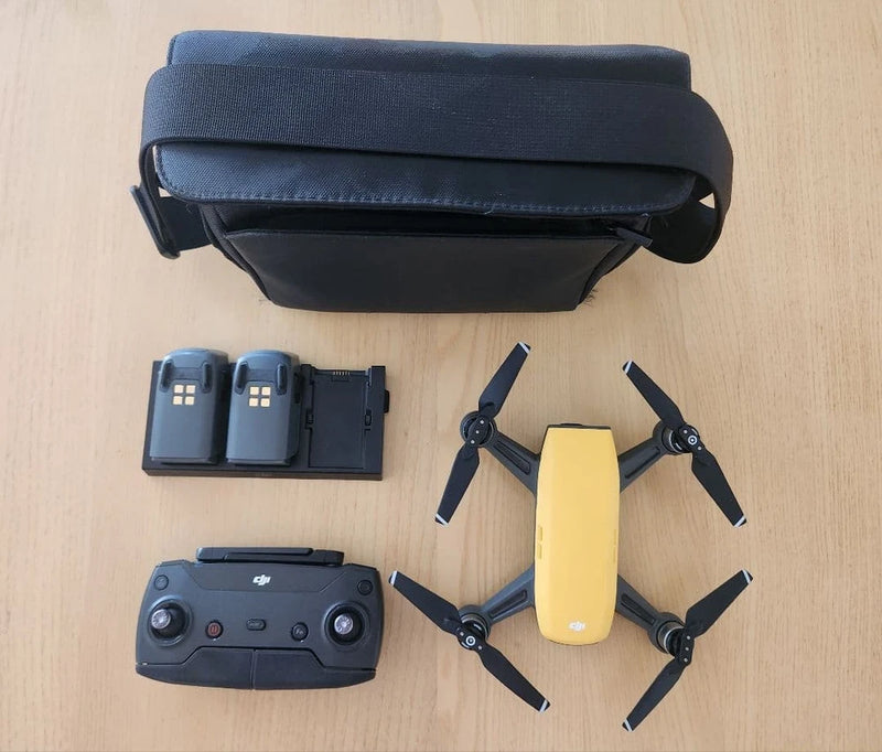 DJI compact quadcopter drone with controller, spare batteries, and carrying case
