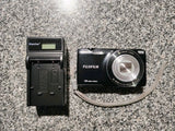 Black Fujifilm FinePix digital camera with lens and battery charger, battery included