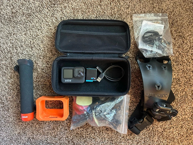 GoPro action camera kit with open hard case, USB cable, orange mount, spare parts