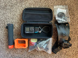 GoPro action camera kit with open hard case, USB cable, orange mount, spare parts