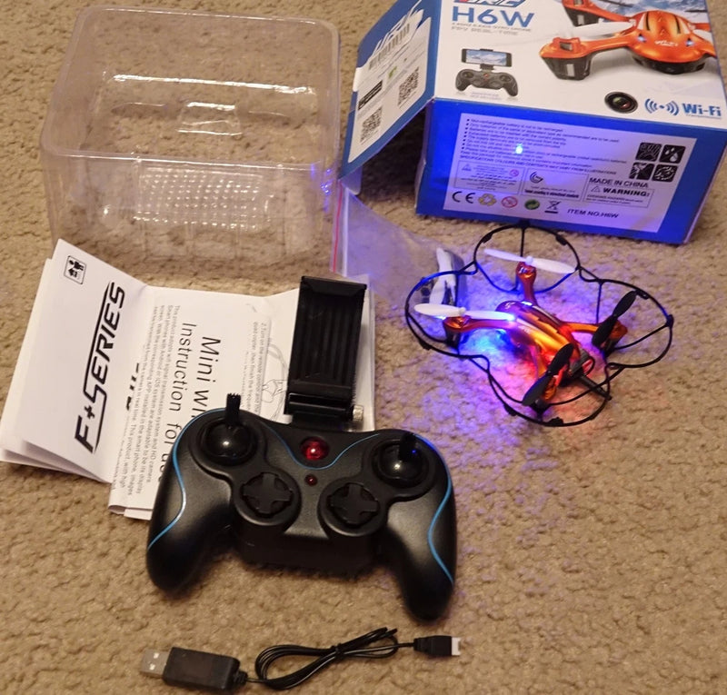 FPV quadcopter drone with black remote controller, charging cable and prop guards