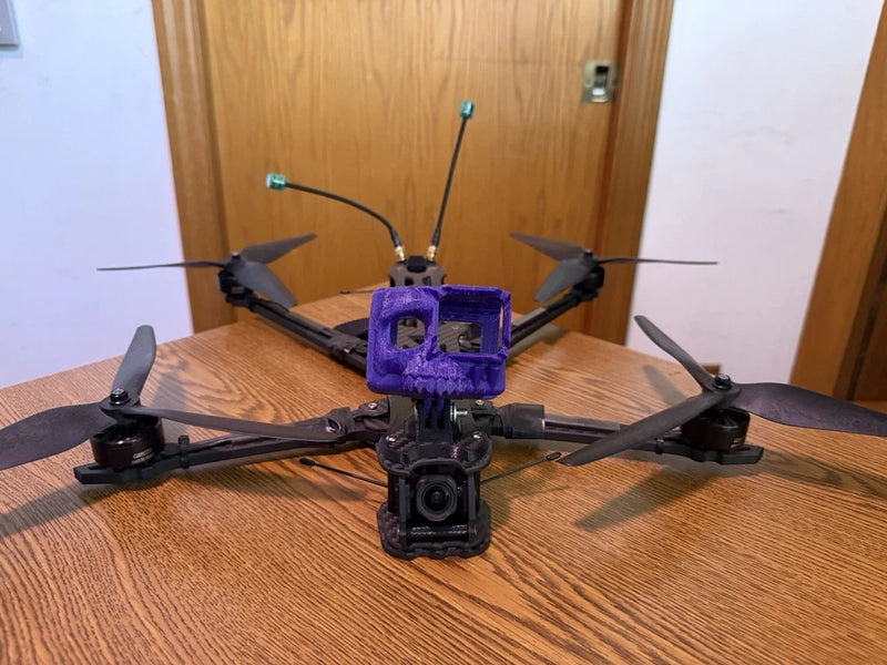 Long-range quadcopter drone with purple frame, front camera, and four propellers