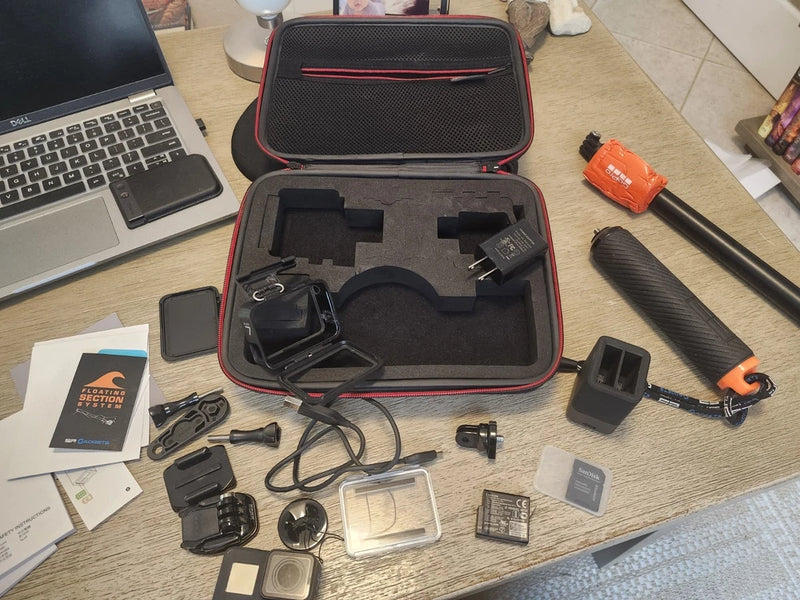 Waterproof action camera case with foam inserts, mounts, and spare battery pack