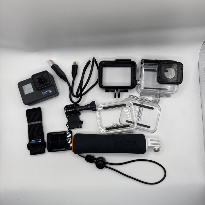 Black action camera bundle with clear waterproof housings, mounts, and straps