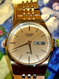 CITIZEN analog quartz watch with gold-tone bracelet, white dial, and date window