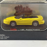 Yellow 1:87 Pontiac Firebird die-cast car in clear blister packaging