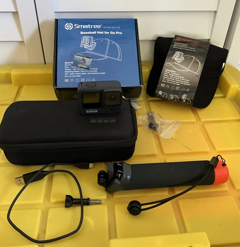 Black action camera with case and mounted accessory arm, cables and mounts included