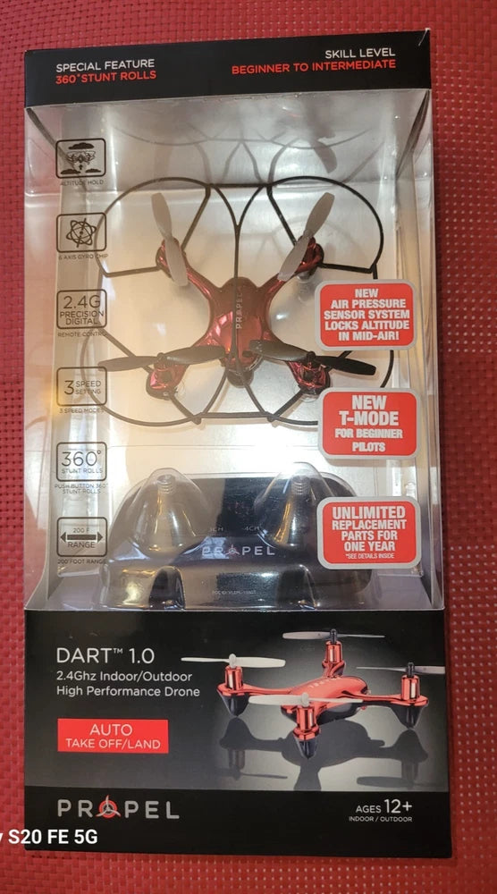 Red quadcopter drone with four propellers on retail box