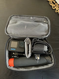 Black action camera kit in gray carry case with mounts and orange accessory tip
