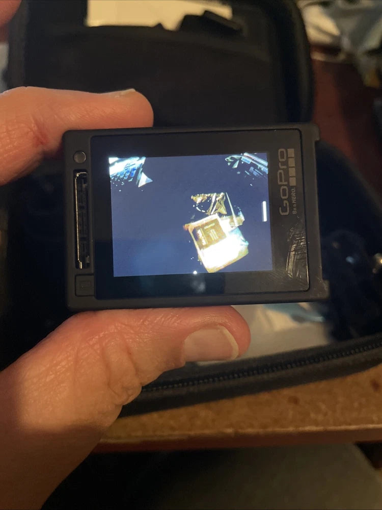 Silver action camera with back LCD screen showing live preview