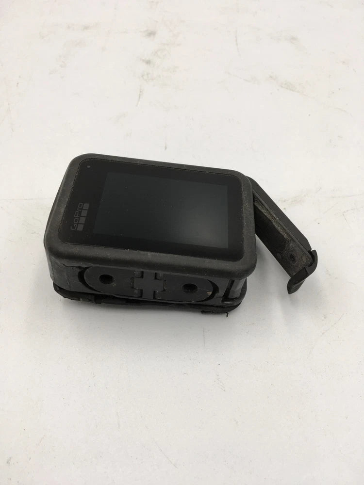 Black action camera housing with cracked area and attached mount strap, damaged AS-IS