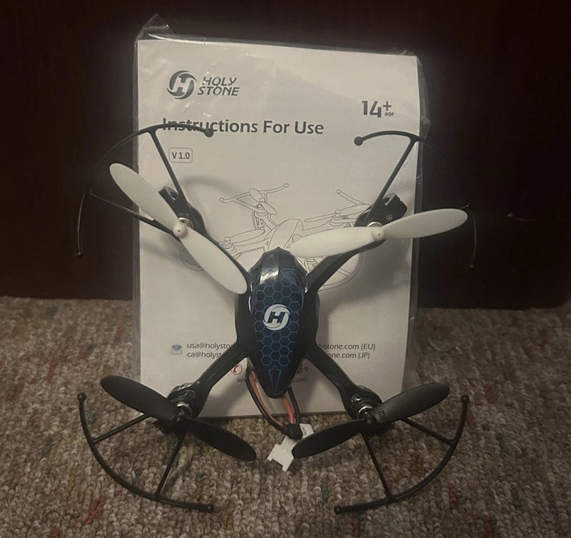 Blue and black quadcopter drone with four propellers, front view