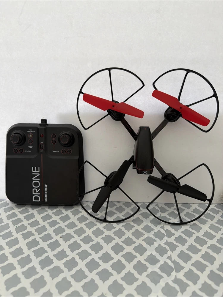 Sharper Image drone parts: black controller and quadcopter with red propellers