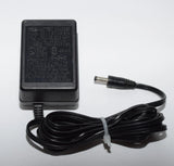 Black battery charger power supply with barrel plug and attached power cord