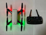 DJI Spark drone with black remote controller and four rotors, light gray body