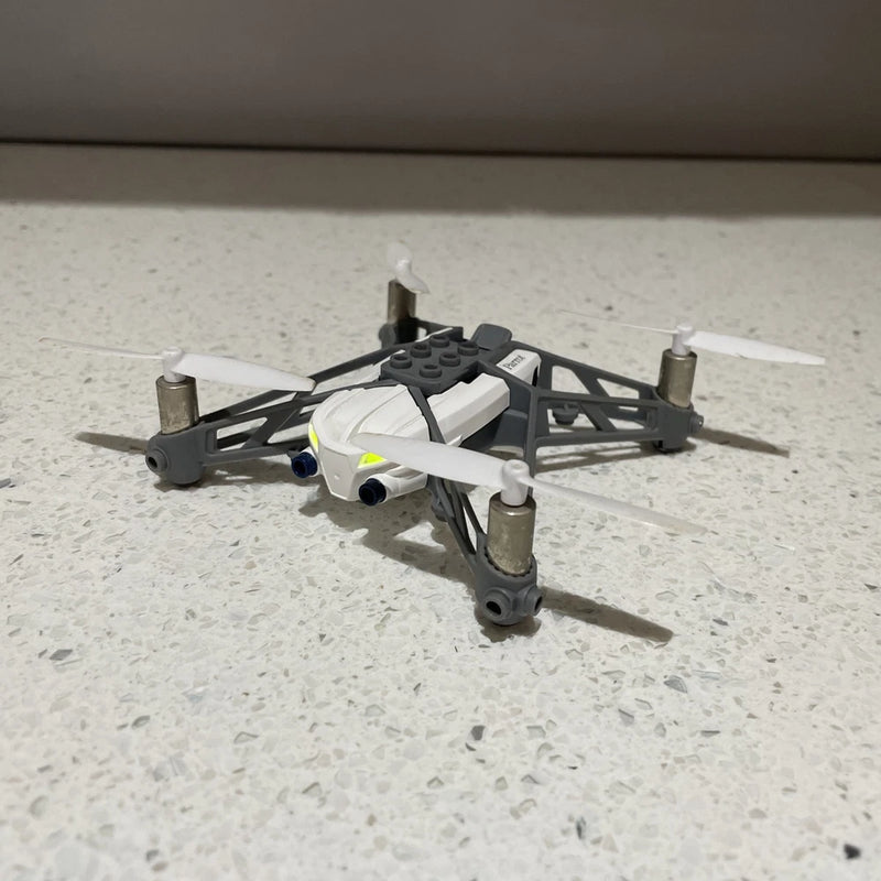 White mini quadcopter drone with four propeller arms and compact body