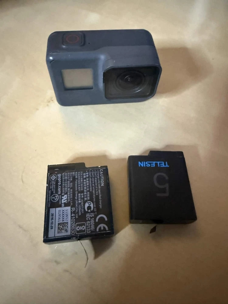 GoPro HERO5 Black action camera with side housing, battery, and small memory card