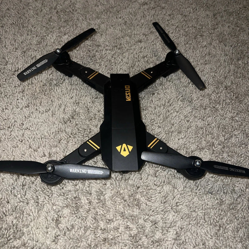 Black quadcopter drone with four propellers and foldable arms