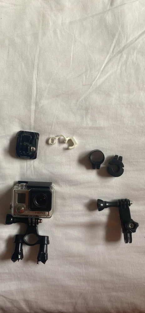 GoPro Hero 3+ action camera with mounts and accessory parts, silver housing