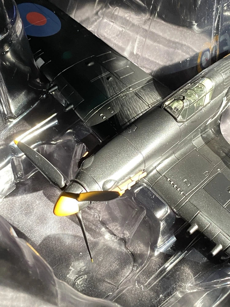 Silver-gray scale model aircraft, close-up of propeller nose and cockpit window