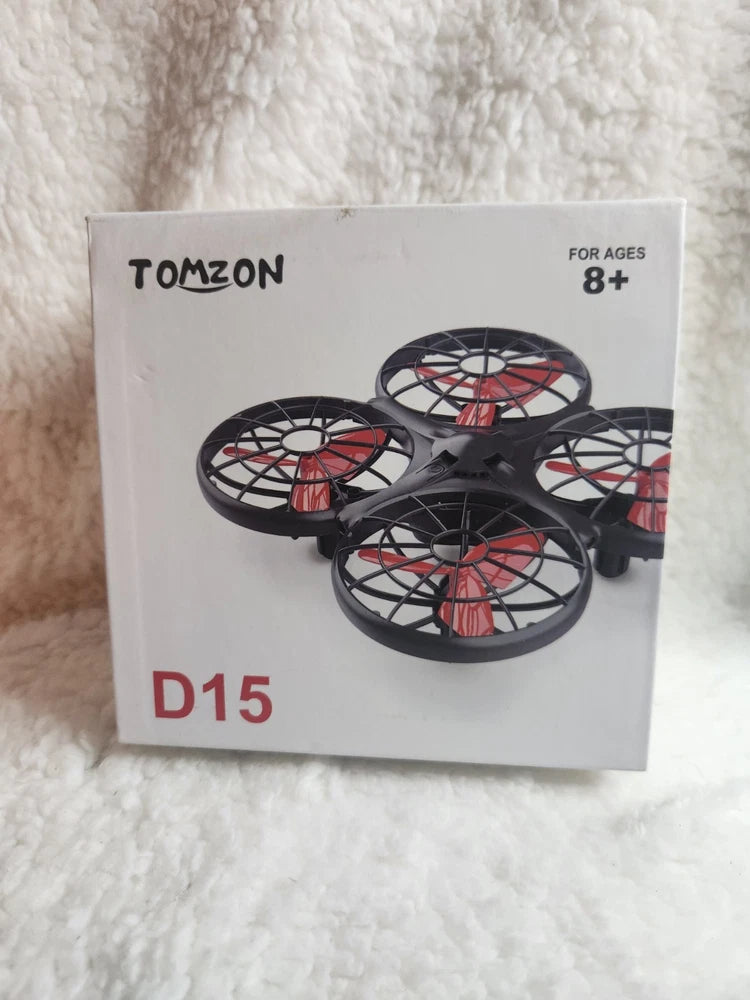 Tomzon D15 hand-operated mini drone box with red and black drone illustration