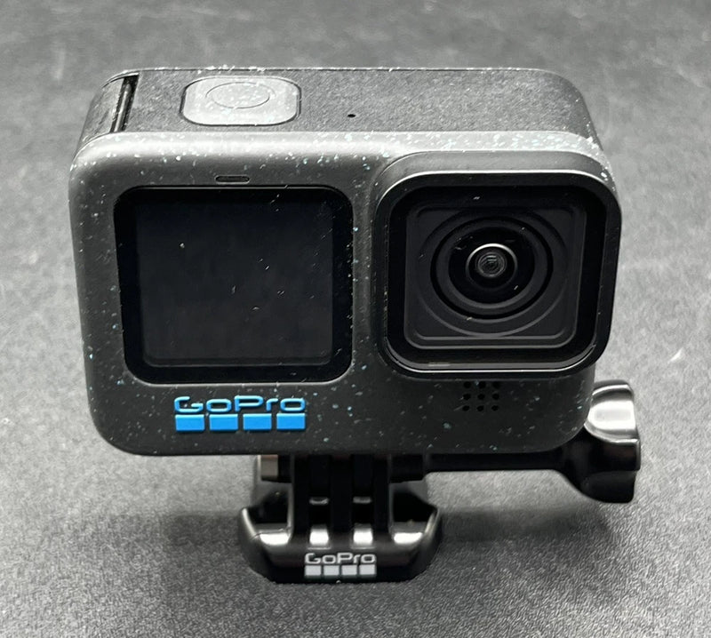 GoPro action camera with black housing, front lens, rear screen, and mount bracket