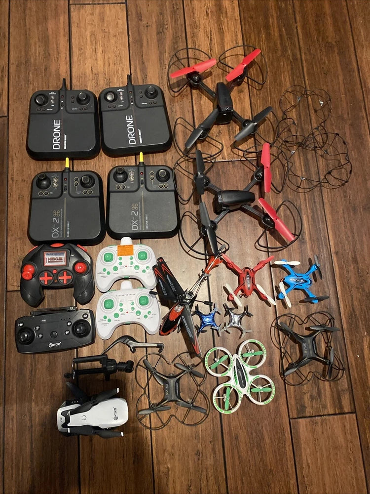 AS-IS drone and controller lot: several small drones with remotes, batteries and cables